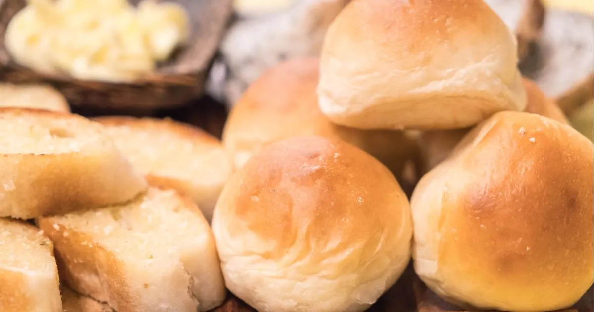 Delicious bread rolls with butter on a rustic wooden cutting board, featuring the Quick Rolls No Yeast concept.