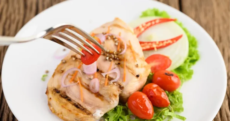 gluten-free chicken with fresh tomato and lettuce on a white plate, highlighting a gluten-free meal option.