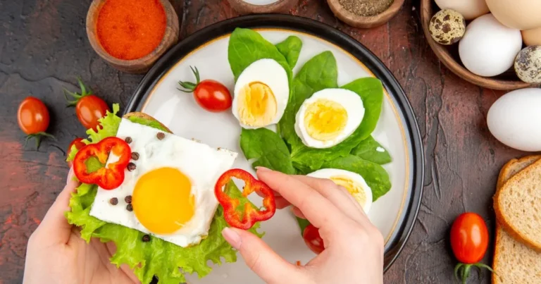 A person displays a plate with a healthy eggs and a variety of other fresh ingredients for a nutritious meal.